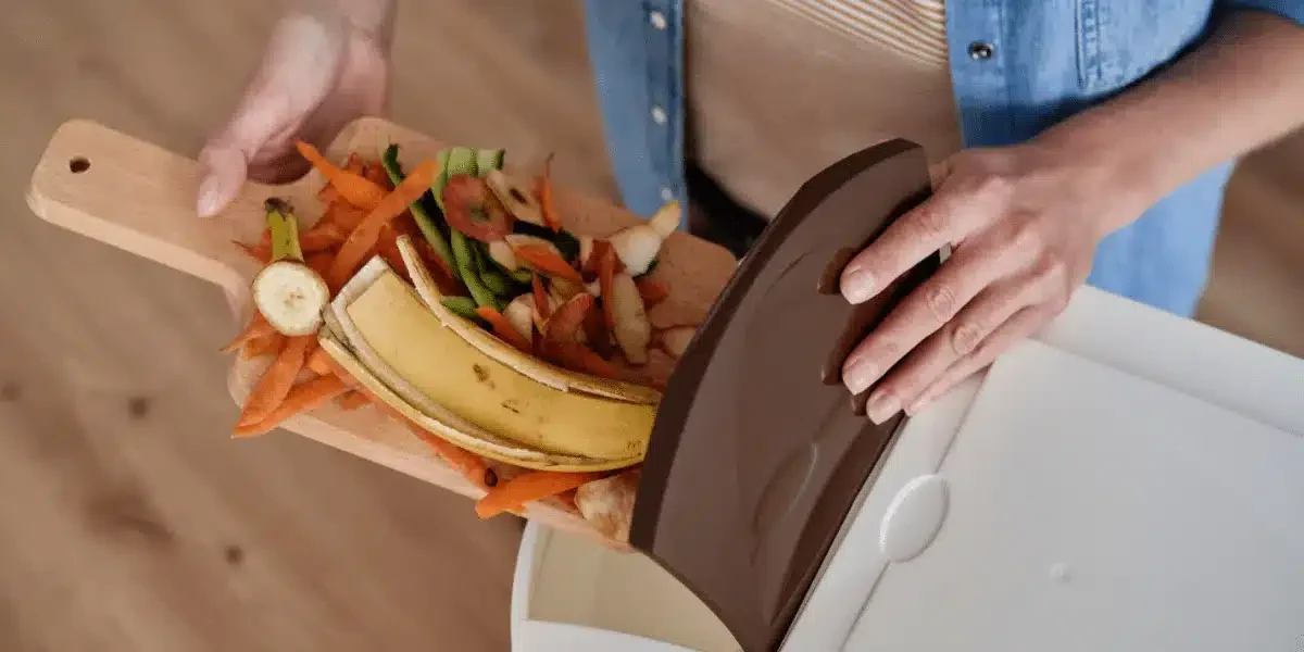 Femme mettant au compost des épluchures de légumes et fruits